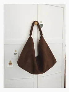 Minimalist retro brown suede large capacity hobo tote bag hanging on a white wardrobe