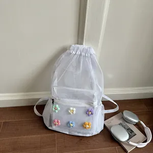 Detailed view of a white mesh backpack with cute colorful crochet flower embellishments.