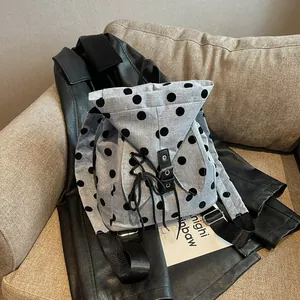 Detailed view of large capacity polka dot backpack resting on a black leather jacket