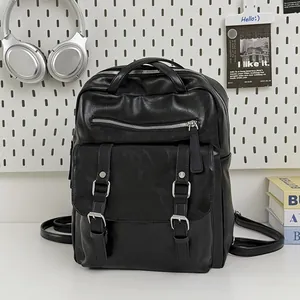 Front view of black large capacity travel backpack featuring decorative silver buckles