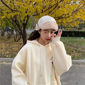 Close-up detail of women's beige sherpa earflap trapper hat showing soft texture and design