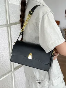 Elegant black rectangular handbag with gold chain strap and geometric clasp