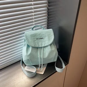 Gros plan d'un sac à dos de voyage bleu clair avec cordon de serrage et rabat design