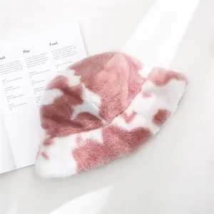 Detail of soft pink cow print faux fur bucket hat on magazine background