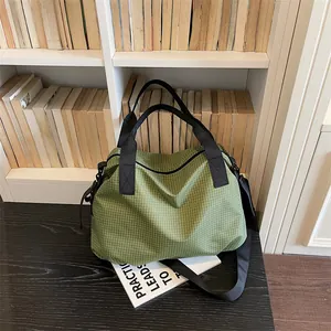 Grande borsa da viaggio a scacchi verdi esposta in una biblioteca accogliente