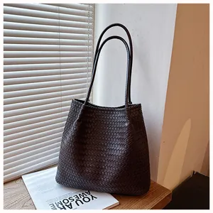 Chic dark brown woven leather tote bag with retro shoulder straps in a lifestyle setting
