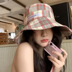 Elegante sombrero de pescador a cuadros para mujer con ala ancha para protección solar.