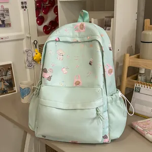 Mint green student backpack with cute cartoon dog patterns in a lifestyle setting