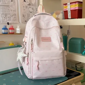 Roze Japanse schoolrugzak met strikpatronen en een sterrenhanger op een houten bureau
