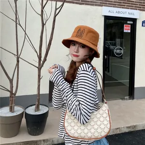 Stylish women's brown bucket hat with cute rabbit ear embroidery in a street style setting