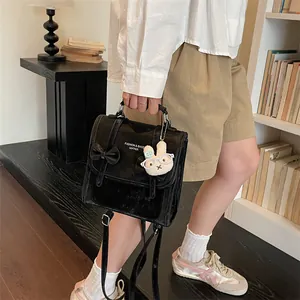 Zaino classico nero stile accademia con grazioso ciondolo a forma di coniglio tenuto dal modello