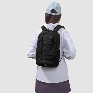 Black outdoor sports backpack with bungee cord detailing worn by a female model