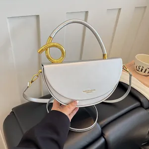 Nahaufnahme einer silbernen Satteltasche mit eleganten goldenen Metalldetails