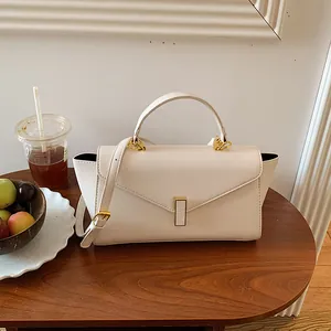 Detailed view of the elegant cream white leather handbag with gold buckle hardware
