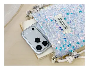 Dettaglio di uno smartphone inserito in una borsa a tracolla bianca con paillettes.