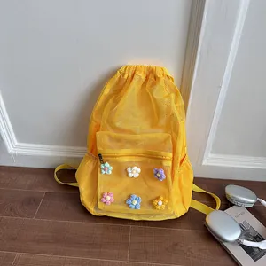 Detailed view of yellow mesh backpack with colorful crochet flower decorations