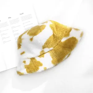 Close-up detail view of yellow and white cow pattern plush bucket hat for winter