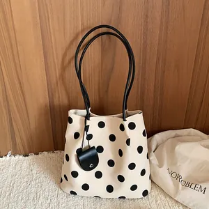 Cream and black polka dot tote bag with elegant thin straps and a small hanging pouch