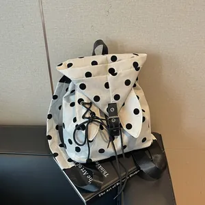 Detailed view of the polka dot canvas backpack featuring unique rabbit ear flaps.