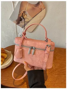 Close-up of pink textured vanity box bag with double zippers and sturdy top handle