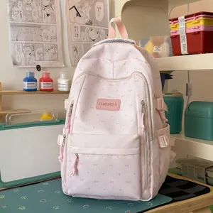 Lichtroze schattige rugzak met strikpatronen in een gezellige studentenbureau-omgeving