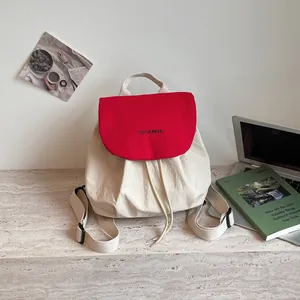 Vue détaillée d'un sac à dos coréen élégant crème et rouge sur un bureau de travail