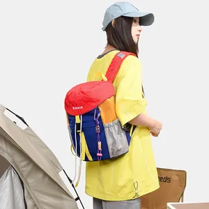 Detailed view of the multi-color block casual backpack worn by a model in outdoor setting