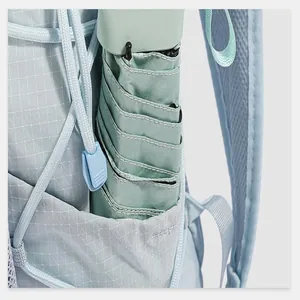 Close-up of a side pocket on a light blue backpack holding a small folded umbrella.