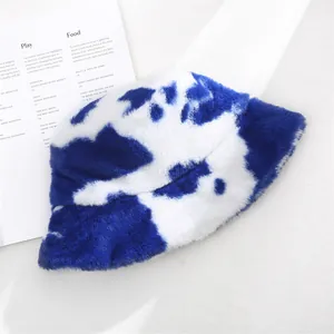 Detailed macro view of soft plush blue and white cow print bucket hat for winter warmth