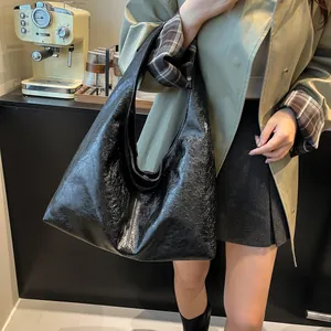 Primer plano de un bolso hobo vintage negro grande con textura de cuero arrugado