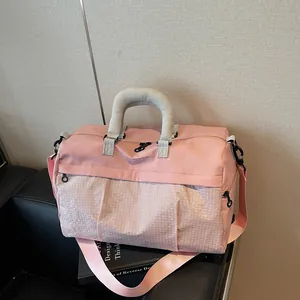 Detail shot of a pink travel bag with grey handles resting on a black leather seat