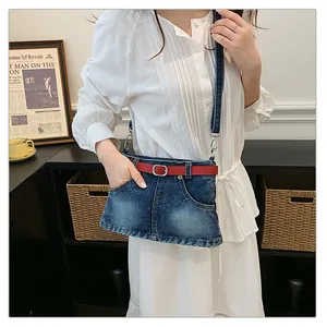 Fashionable denim skirt-shaped crossbody bag with red belt detail worn with a dress
