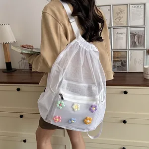 Detailed back view of a white mesh backpack featuring colorful crochet flower patches