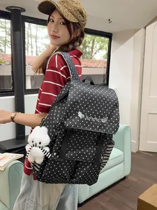 Stylish women's black backpack with white star patterns and plush bear pendant