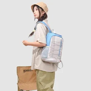 Side view of a student wearing a blue and grey outdoor backpack with elastic cords