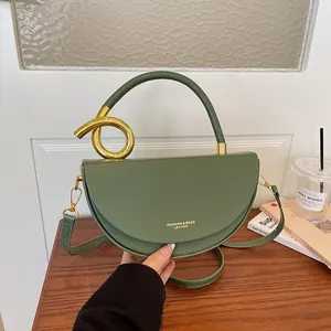 Detailansicht einer grünen Satteltasche mit einem einzigartigen goldenen Ringgriff