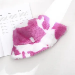 Macro view of a soft pink and white cow print plush bucket hat for winter style