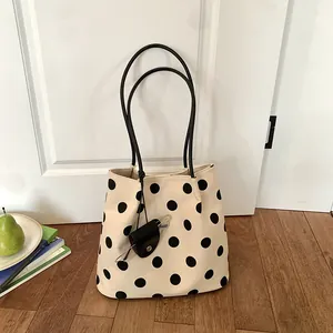 Chic polka dot canvas tote bag with black handles and small hanging pouch accessory