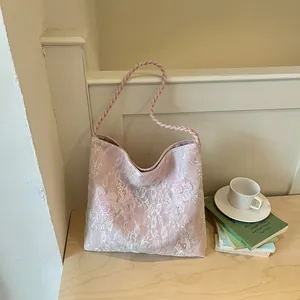 Elegant pink lace shoulder bag with floral embroidery and braided strap detail
