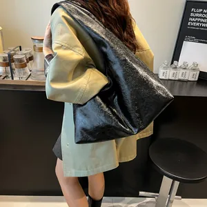 Vista detallada de un bolso hobo vintage grande negro con textura arrugada para mujer