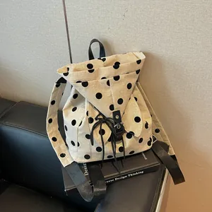 Polka dot canvas backpack for women shown on a design book in a modern room