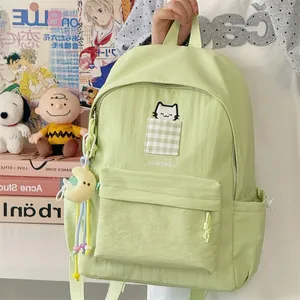 Detail view of light green student backpack with cute cat embroidery and moon charm