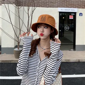 Close-up of a stylish brown bucket hat with embroidered rabbit ears on a model