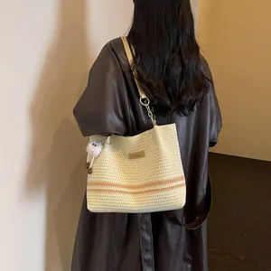 Stylish woven tote bag with stripes and plush charm shown from a back perspective.