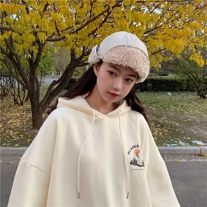 Cute Japanese style beige earflap hat with faux shearling trim worn by model in autumn