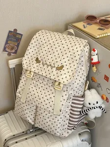 Elegant star pattern backpack for women placed on a white suitcase in a travel setting.