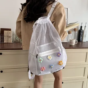 Lifestyle detail of white mesh drawstring backpack with colorful knit flower appliques