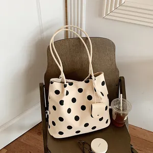 Retro French style beige polka dot tote bag displayed on a wooden chair with accessories