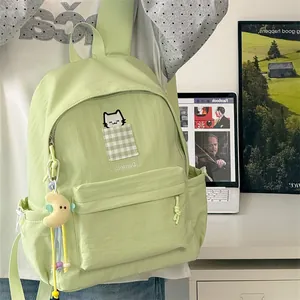 Close-up of Japanese style green student backpack with cute cat embroidery and pendant