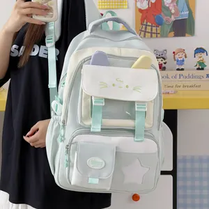 Primer plano de una mochila escolar verde menta con diseño de gato y varios compartimentos.